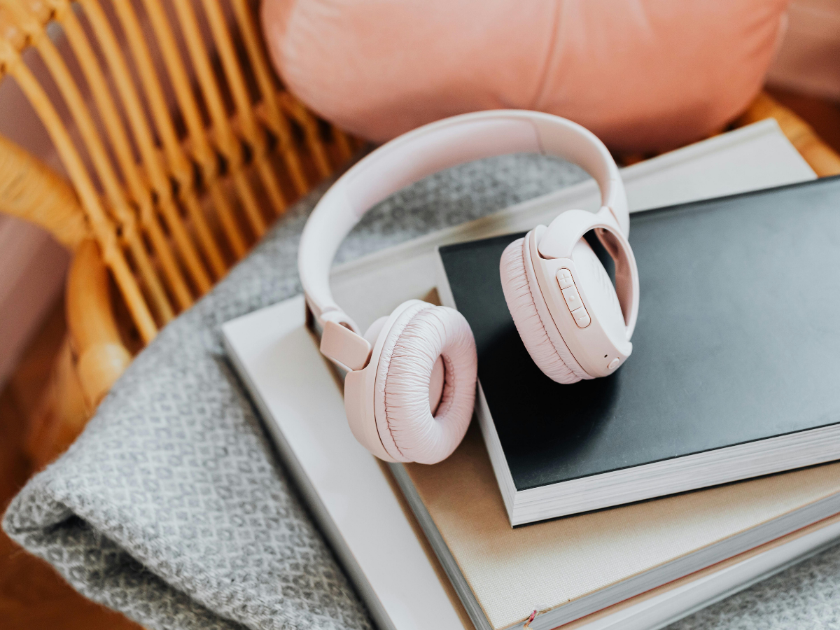 Headphones resting beside a cup in a quiet listening space