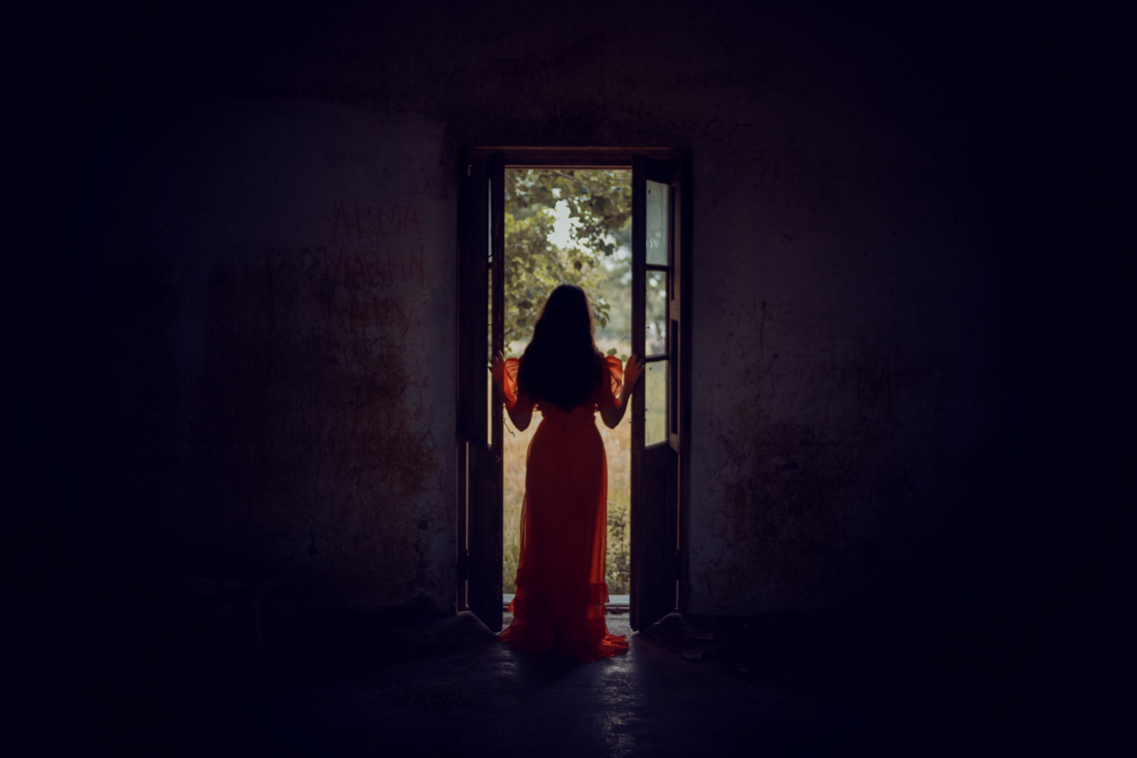 Woman standing at a doorway illuminated by daylight